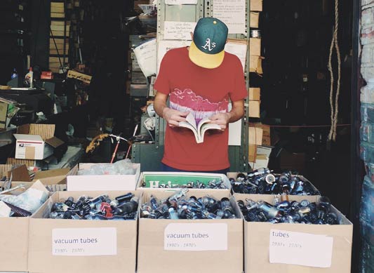 Passive income with thirft shop finds cover photo. A man looking through boxes.