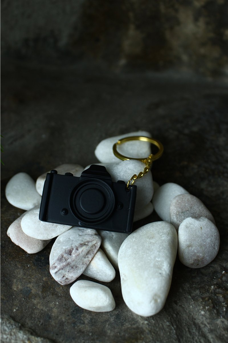 3D Printed dslr camera keychain for photographers, on white stone